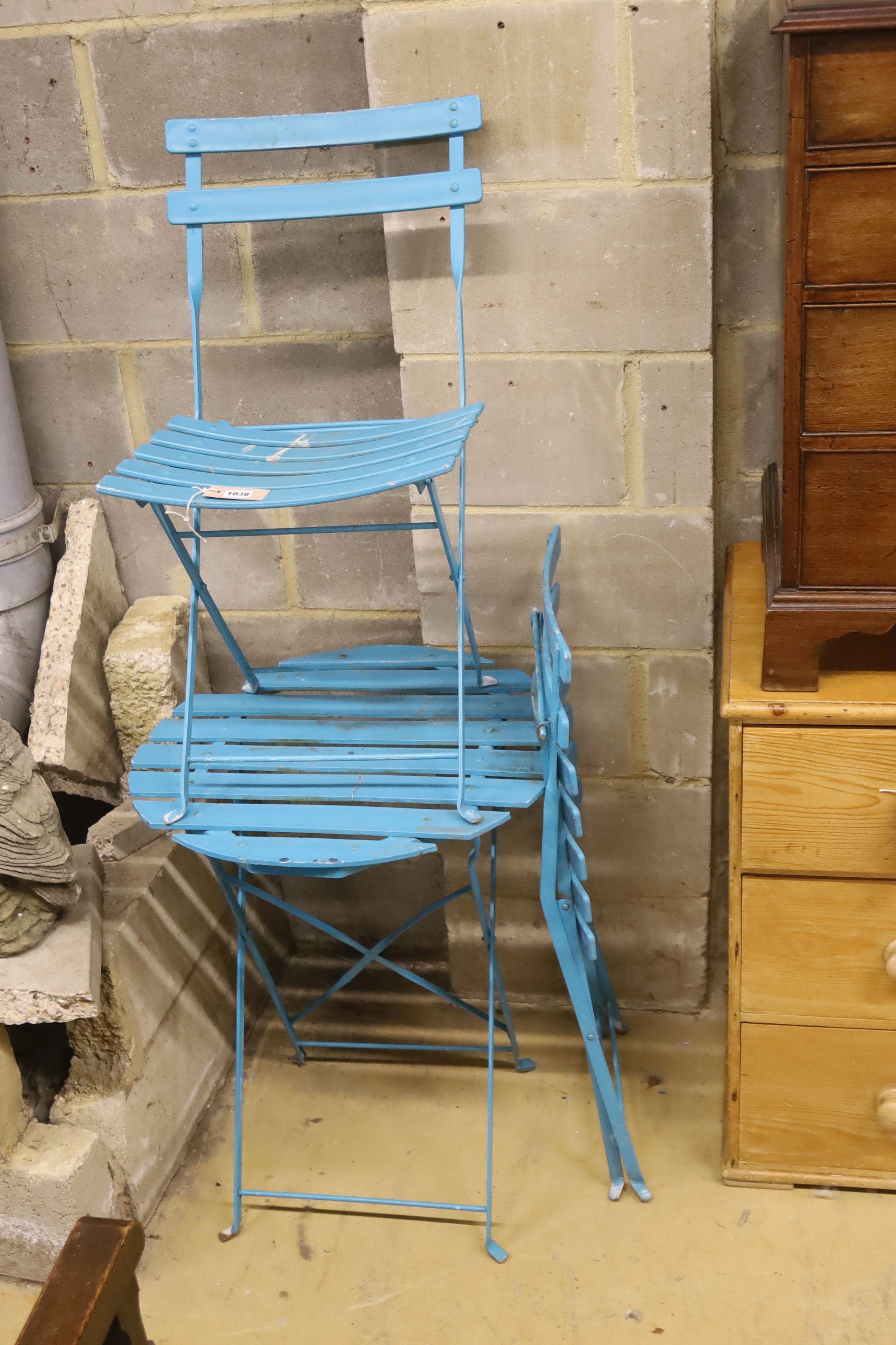 A slatted wrought iron folding garden table, 60cm diameter together with two matching chairs